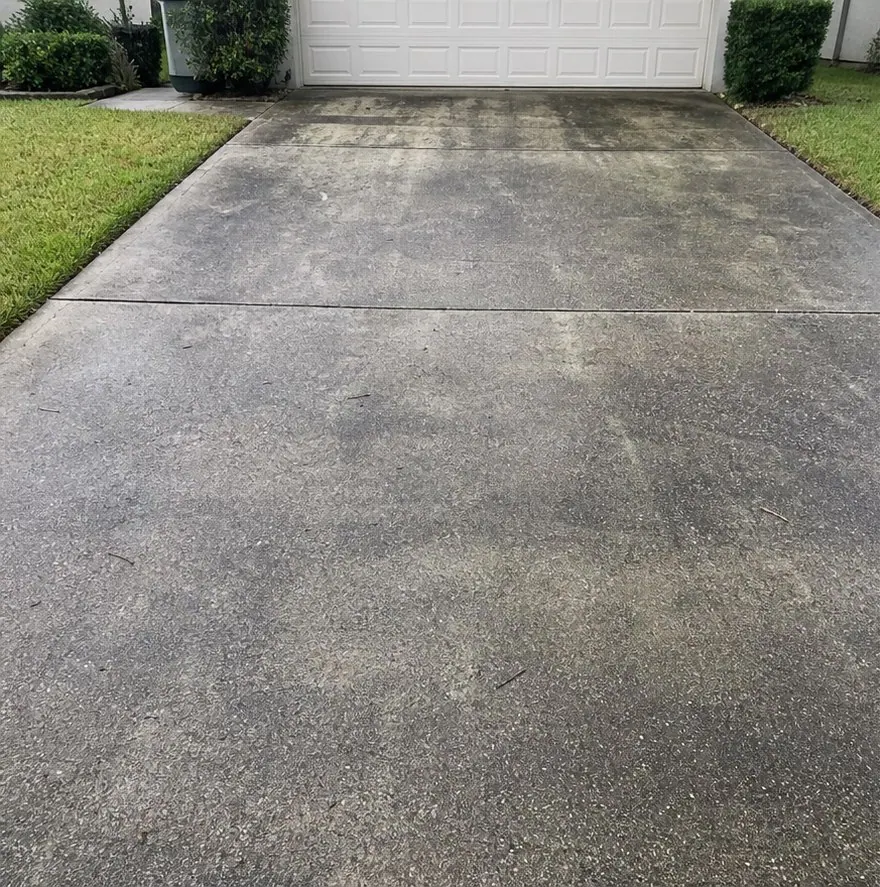 Weathered concrete driveway before pressure washing.